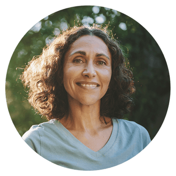 Happy woman with curly hair smiling outdoors, showcasing a positive testimonial for Laboratoires Uma.