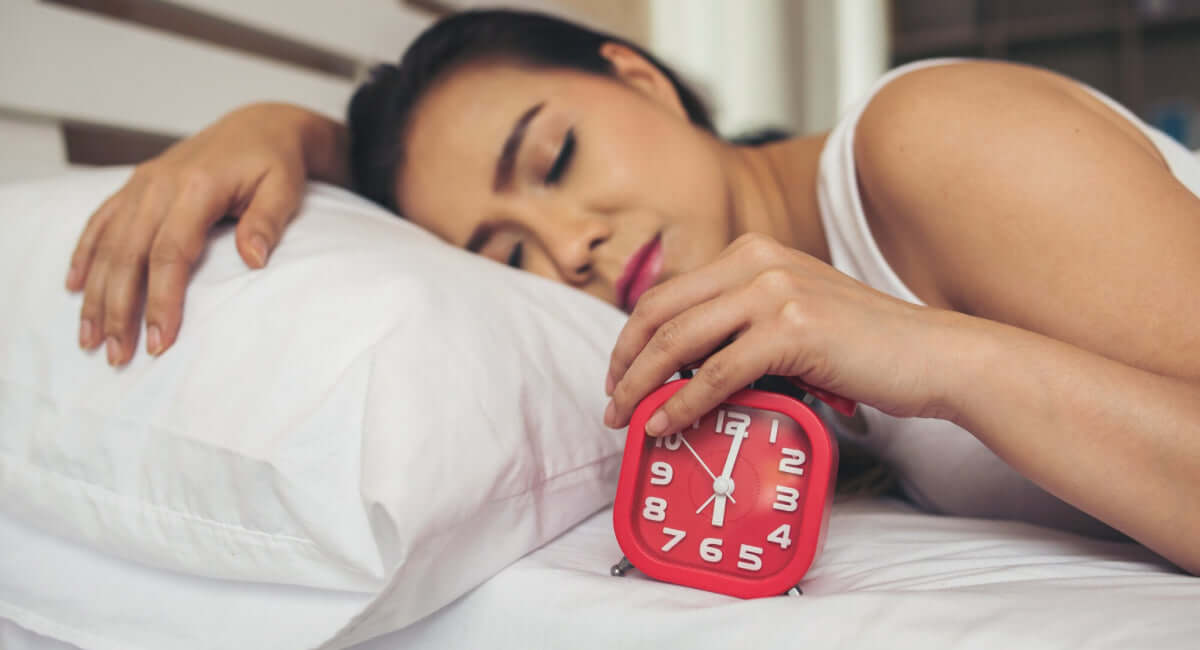 Femme allongée éveillée dans son lit illustrant les troubles du sommeil liés au stress pendant la ménopause